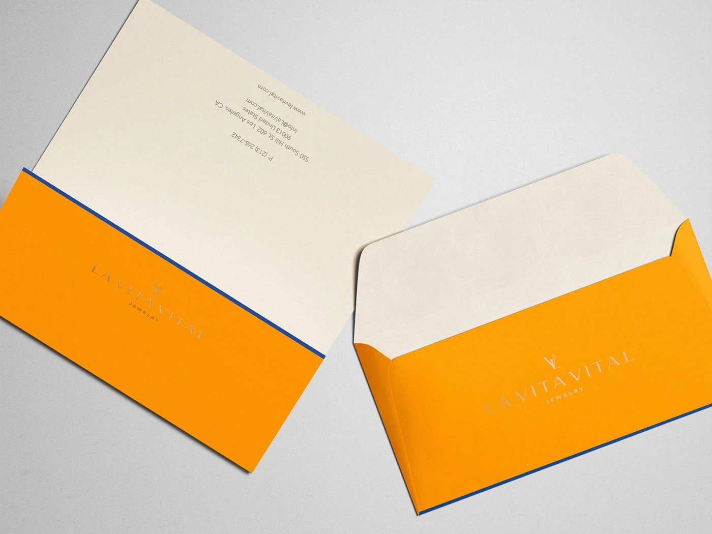 La Vita Vital stationery: orange envelopes with a foil-stamped mark and a painted cobalt edge